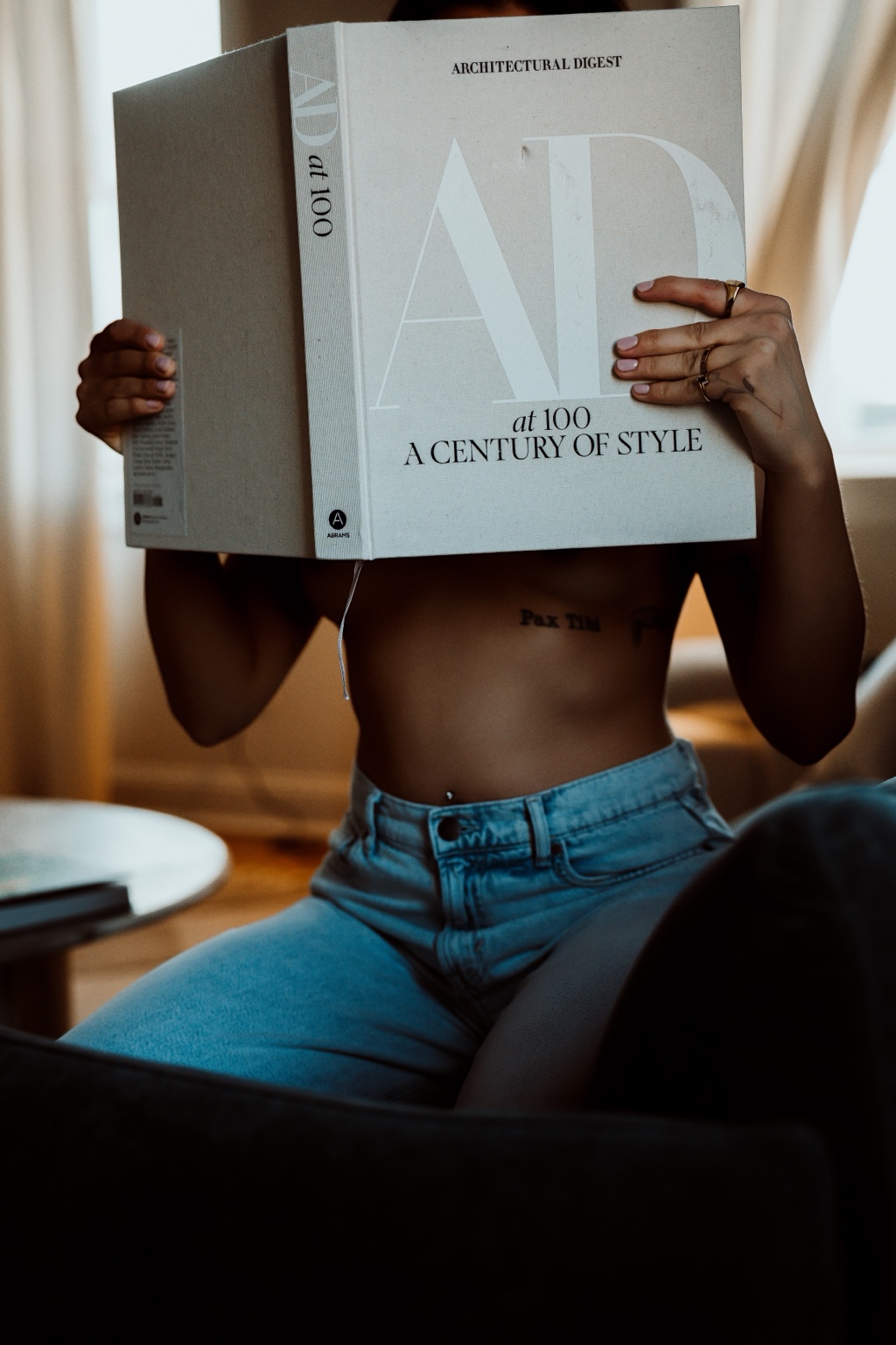Client holding an Architectural Digest book while wearing blue jeans